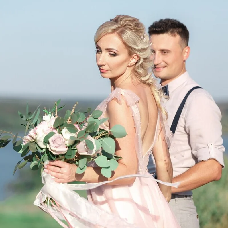 Panna młoda i pan młody przytuleni na weselu w letni dzień